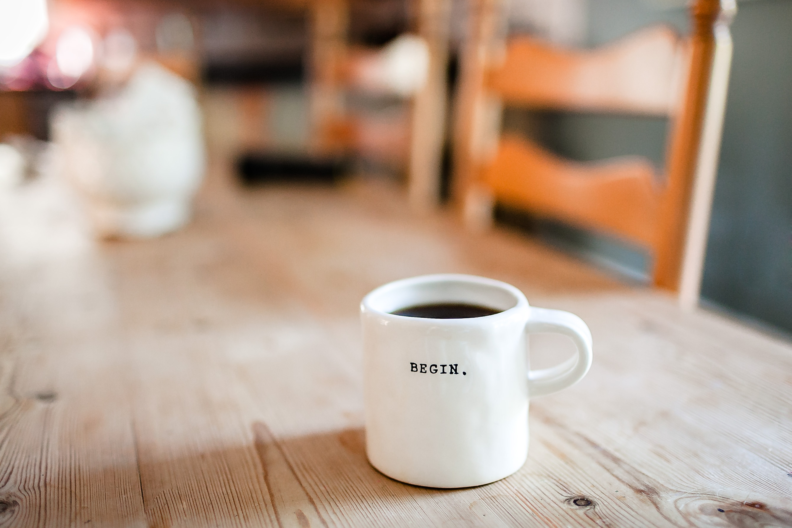 A mug of coffee on a table, it says: begin